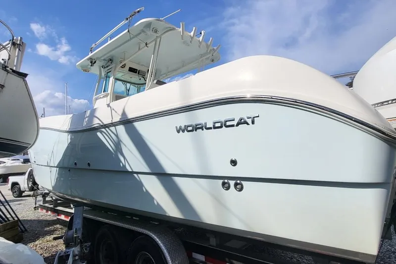 Slide: The Image of 2019 World Cat 320 CC boat on trailer under clear sky. - 26