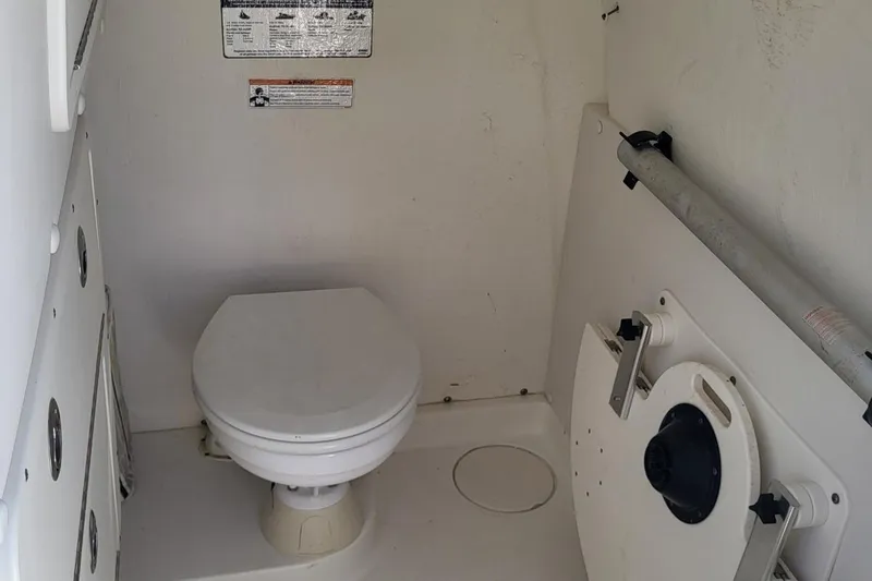 Slide: The Image of Interior of 2019 World Cat 320 CC boat featuring a compact marine toilet. - 4