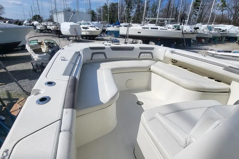 Slide: The Image of 2019 World Cat 320 CC boat interior with spacious seating, docked among other boats. - 7
