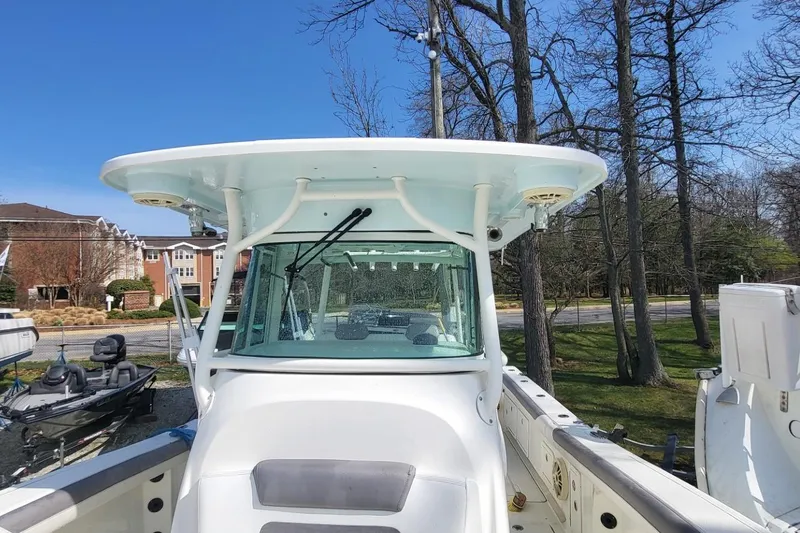 Slide: The Image of 2019 World Cat 320 CC boat with T-top, docked near trees and buildings. - 8