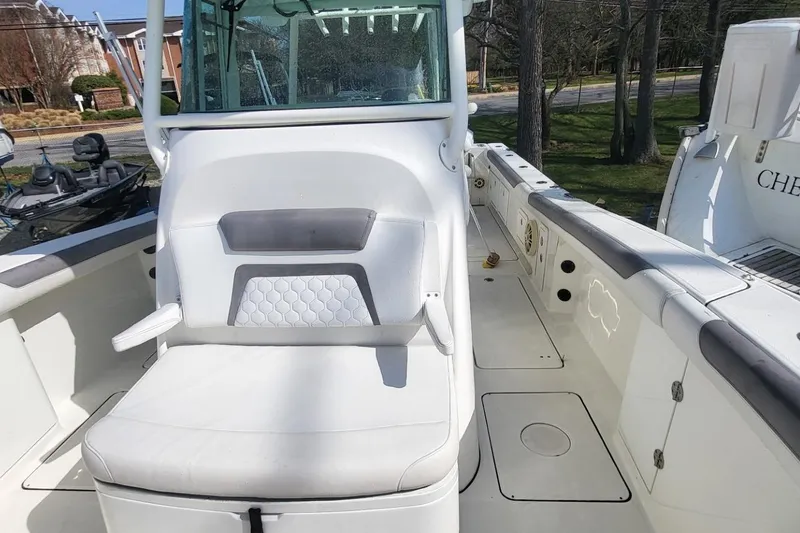 Slide: The Image of 2019 World Cat 320 CC boat interior with white seating and spacious deck. - 9