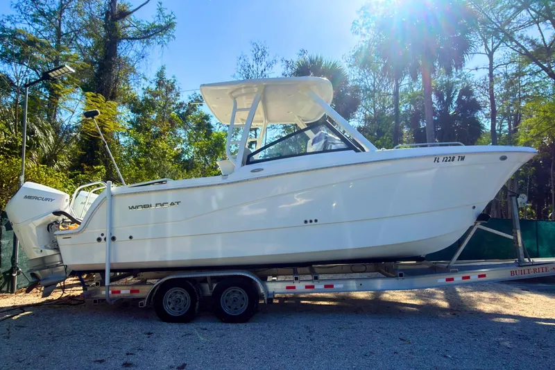The Image of 2024 World Cat 260 DC-X boat on trailer, surrounded by trees and sunlight. - 0