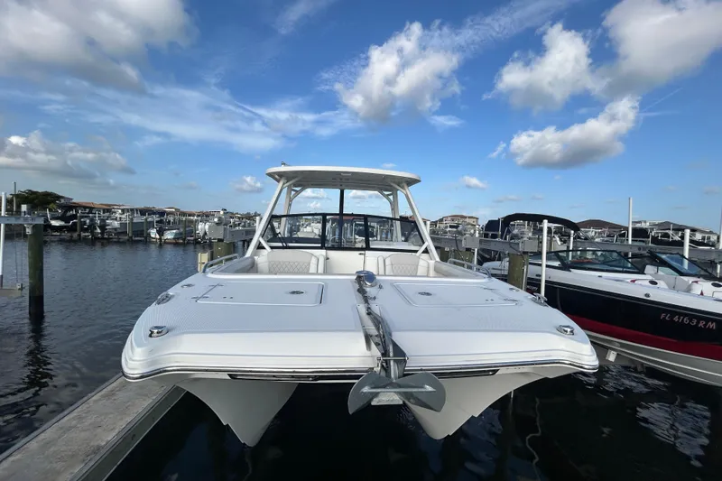 Slide: The Image of 2024 World Cat 260 DC-X boat docked at marina under blue sky. - 2