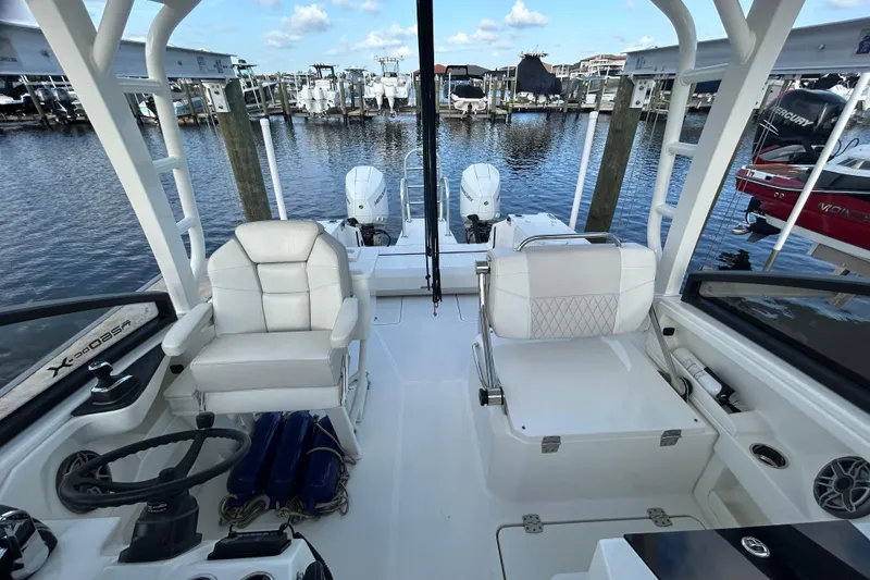 Slide: The Image of 2024 World Cat 260 DC-X boat interior with white seating and dual engines at a marina. - 5