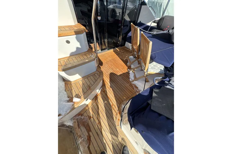 Slide: The Image of 2018 Sea Ray L590 Fly yacht deck with wooden flooring and seating area. - 10