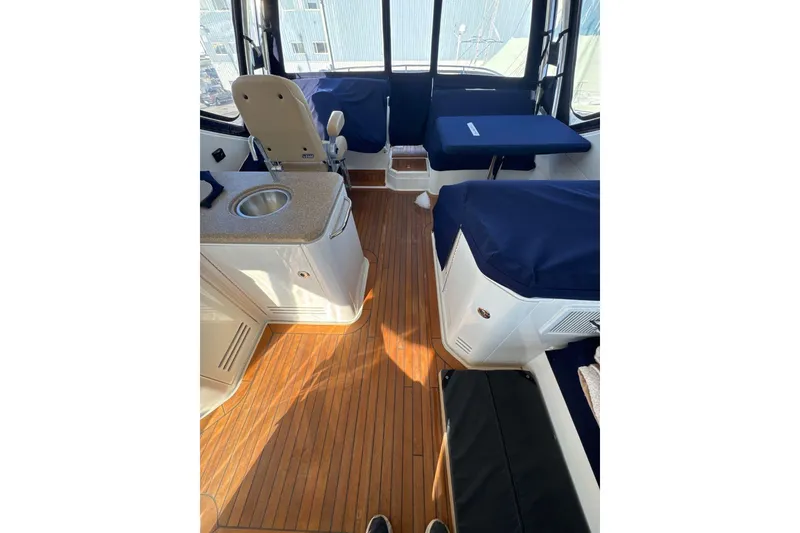 Slide: The Image of Interior of 2018 Sea Ray L590 Fly yacht with wood flooring and seating area. - 11