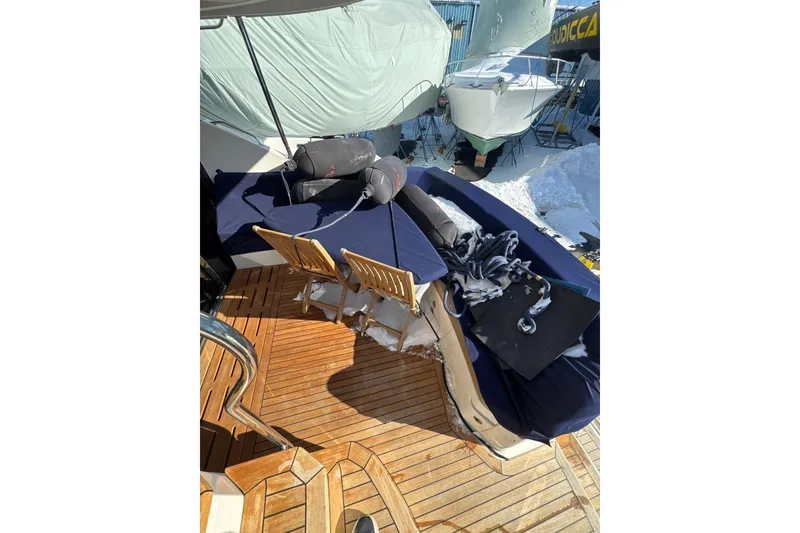 Slide: The Image of 2018 Sea Ray L590 Fly yacht deck with wooden flooring and covered seating area. - 13