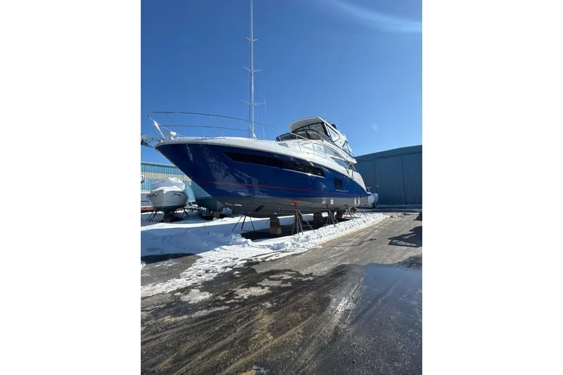 Slide: The Image of 2018 Sea Ray L590 Fly yacht on stands in snowy marina. - 2