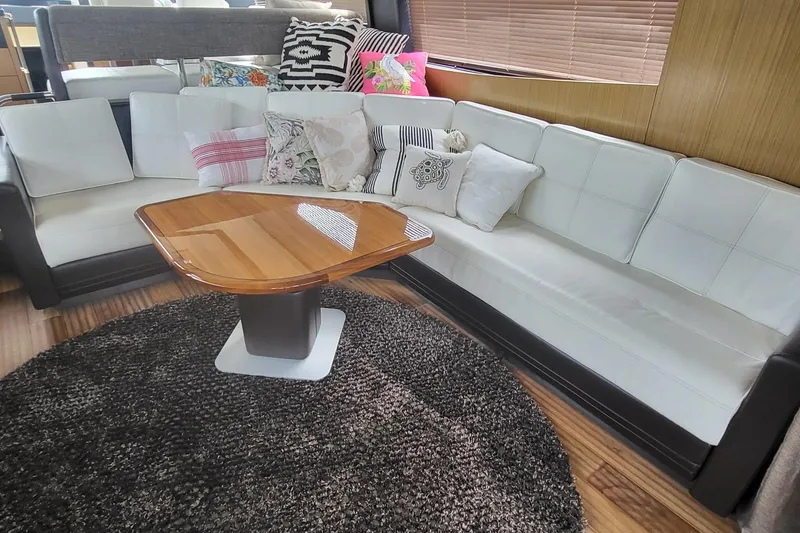 Slide: The Image of Luxurious 2018 Sea Ray L590 Fly yacht interior with plush seating and elegant wooden table. - 22