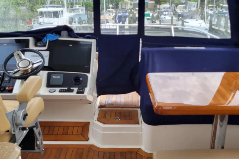 Slide: The Image of 2018 Sea Ray L590 Fly yacht interior with helm, steering wheel, and wooden table. - 29