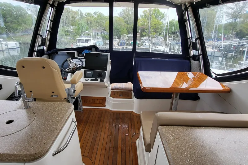 Slide: The Image of Interior of 2018 Sea Ray L590 Fly yacht with helm, seating, and wooden table. - 30