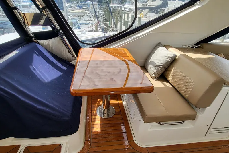 Slide: The Image of Luxurious interior of 2018 Sea Ray L590 Fly yacht with polished wood table and cushioned seating. - 39