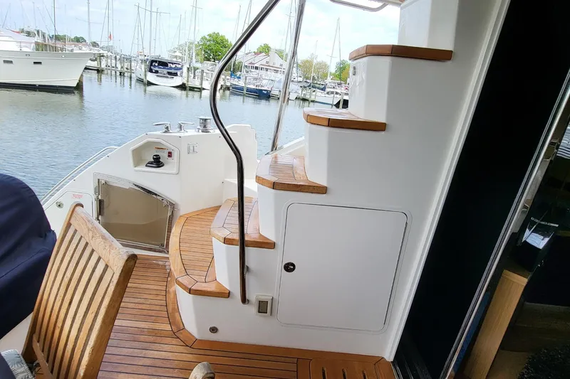 Slide: The Image of 2018 Sea Ray L590 Fly yacht with wooden deck and marina view. - 45