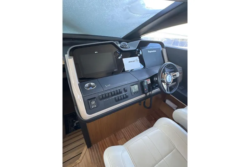 Slide: The Image of 2018 Sea Ray L590 Fly yacht helm with modern navigation equipment and leather seating. - 5
