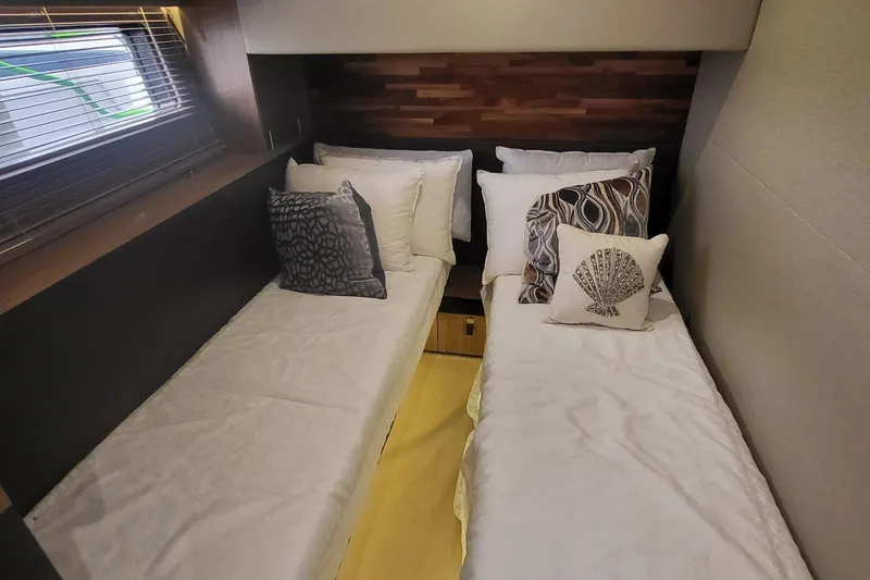 Slide: The Image of 2018 Sea Ray L590 Fly cabin with twin beds and decorative pillows. - 51