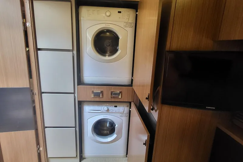 Slide: The Image of Laundry area with stacked washer and dryer in 2018 Sea Ray L590 Fly yacht. - 53