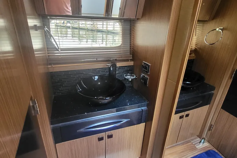 Slide: The Image of Luxurious bathroom interior of 2018 Sea Ray L590 Fly yacht with modern sink and wood finish. - 55