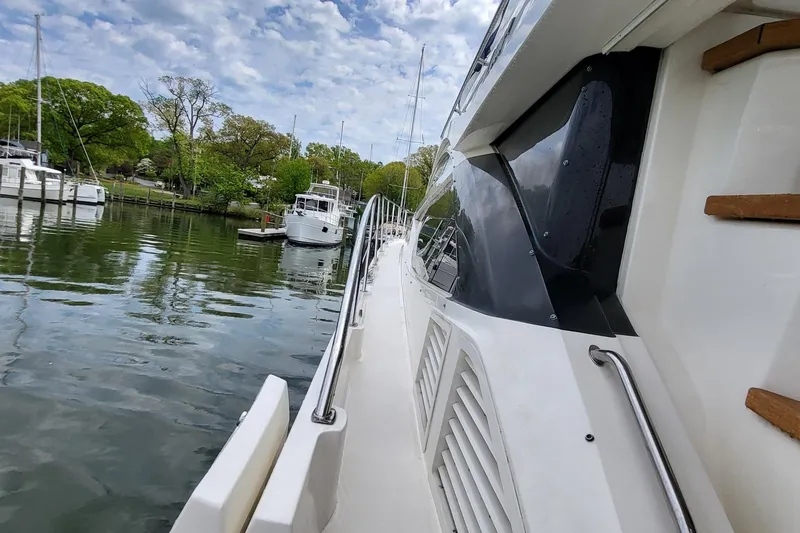 Slide: The Image of 2018 Sea Ray L590 Fly yacht docked in a serene marina setting. - 64
