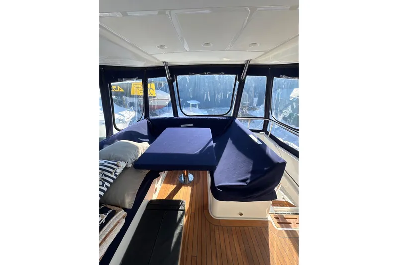 Slide: The Image of Interior of 2018 Sea Ray L590 Fly yacht with blue seating and wooden flooring. - 9