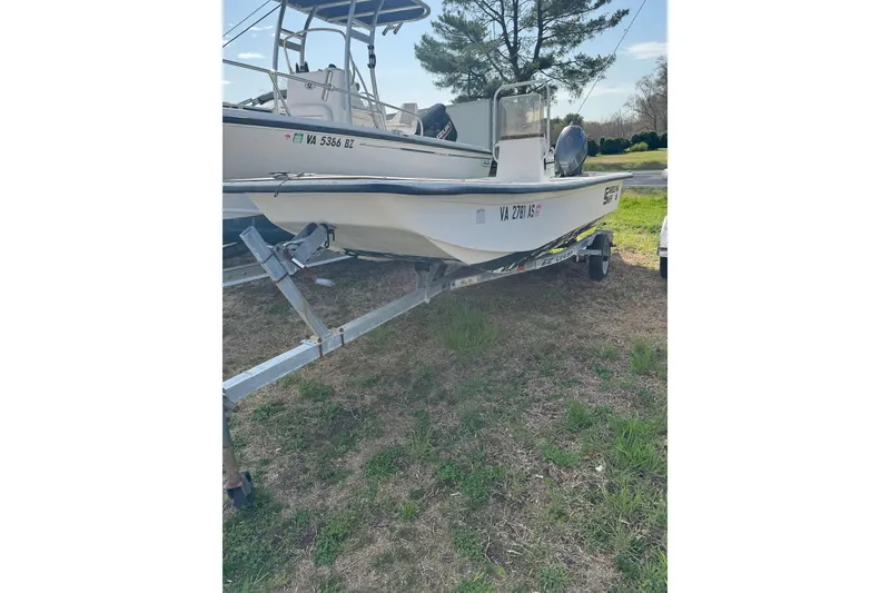 The Image of 1998 Carolina Skiff 16 boat on trailer, parked on grass, with registration numbers visible. - 0