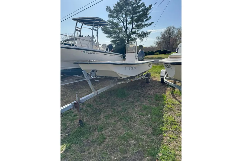 Slide: The Image of 1998 Carolina Skiff 16 boat on trailer, parked outdoors under clear sky. - 13