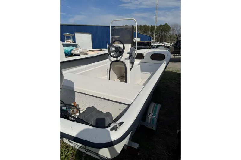 Slide: The Image of 1998 Carolina Skiff 16 boat with center console, parked outdoors under blue sky. - 2