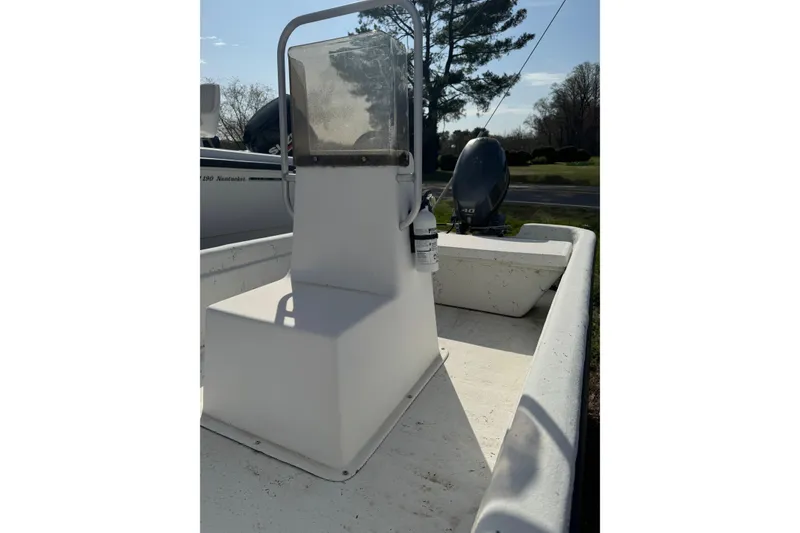 Slide: The Image of 1998 Carolina Skiff 16 boat interior with console and outboard motor in sunlight. - 5