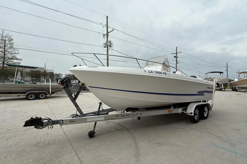 Slide: The Image of 2001 Pro-Line 22 Sport boat on trailer, parked outdoors under cloudy sky. - 8
