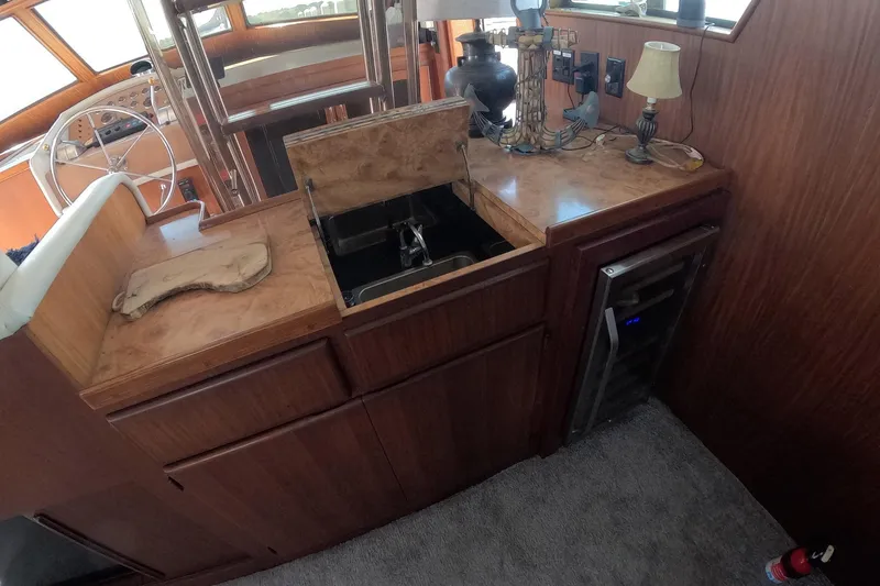 Slide: The Image of 1987 Hatteras 54 Motor Yacht interior with wooden cabinetry and sink area. - 10