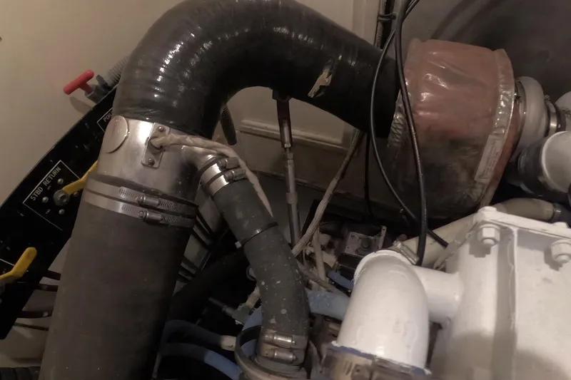 Slide: The Image of Engine compartment of a 1987 Hatteras 54 Motor Yacht, showing hoses and mechanical components. - 103