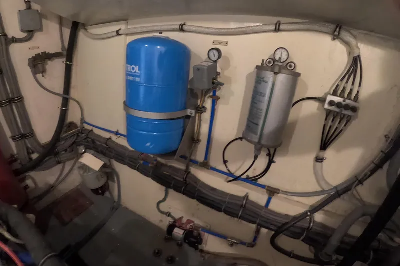 Slide: The Image of Engine room of 1987 Hatteras 54 Motor Yacht with blue pressure tank and gauges. - 105