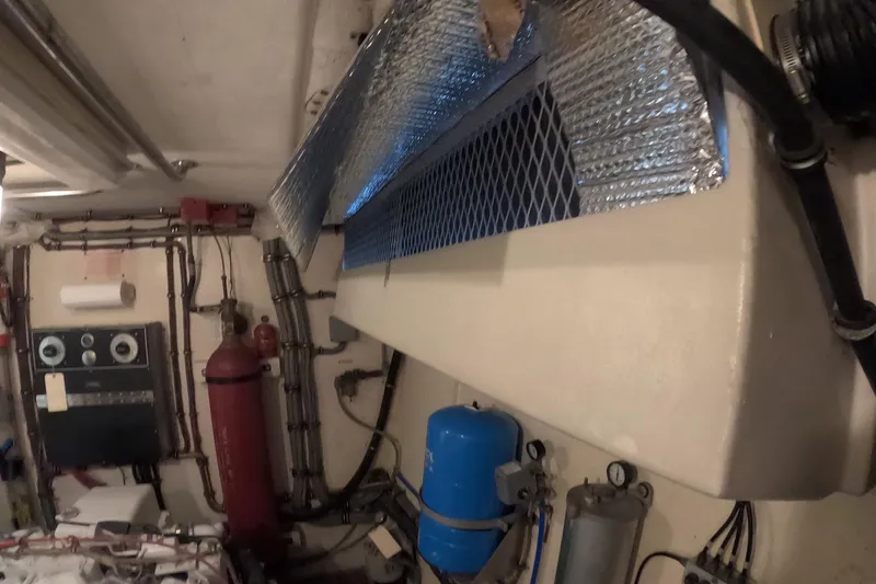 Slide: The Image of Engine room of a 1987 Hatteras 54 Motor Yacht with various equipment and piping. - 108