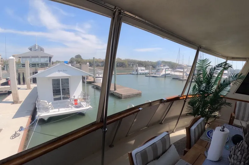 Slide: The Image of 1987 Hatteras 54 Motor Yacht docked at marina with scenic waterfront view. - 109
