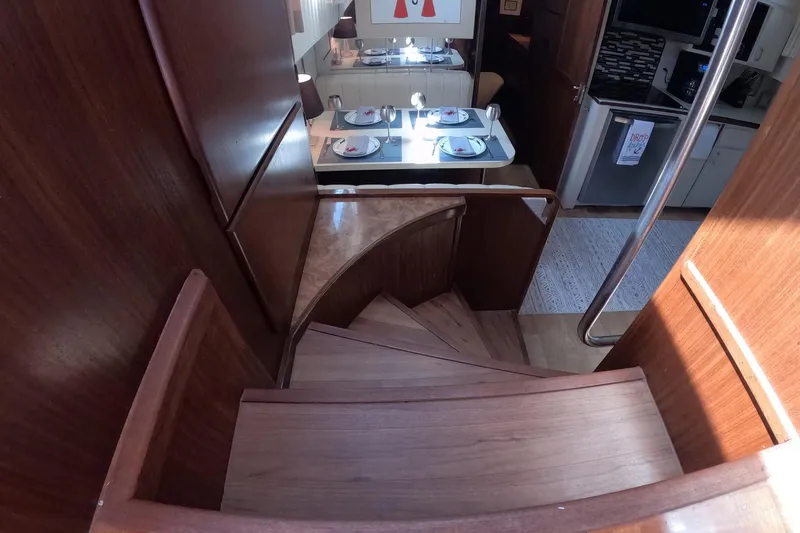 Slide: The Image of Interior view of 1987 Hatteras 54 Motor Yacht, featuring wooden staircase and dining area. - 11