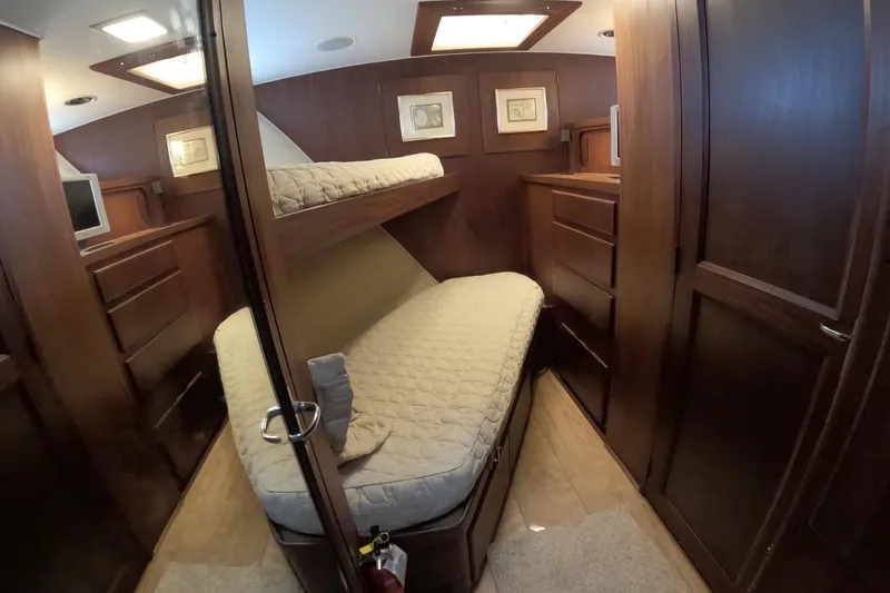 Slide: The Image of Interior cabin of 1987 Hatteras 54 Motor Yacht with wooden furnishings and bunk beds. - 15