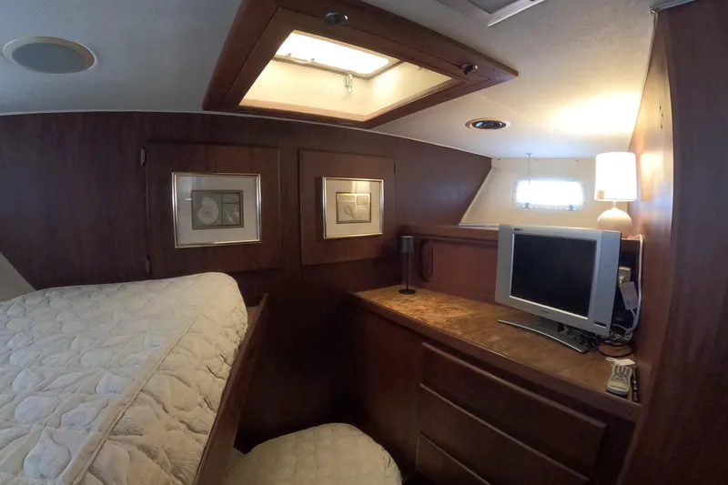 Slide: The Image of Interior of 1987 Hatteras 54 Motor Yacht with cozy cabin, TV, and elegant wood finish. - 16