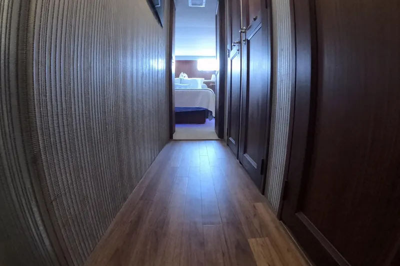 Slide: The Image of Hallway view inside 1987 Hatteras 54 Motor Yacht, featuring wooden flooring and walls. - 25