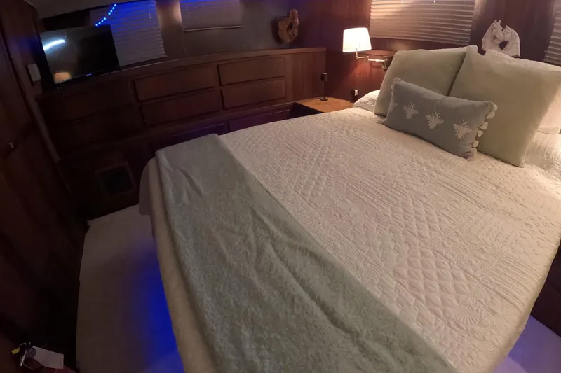 Slide: The Image of Luxurious bedroom interior of 1987 Hatteras 54 Motor Yacht with elegant bedding and ambient lighting. - 26