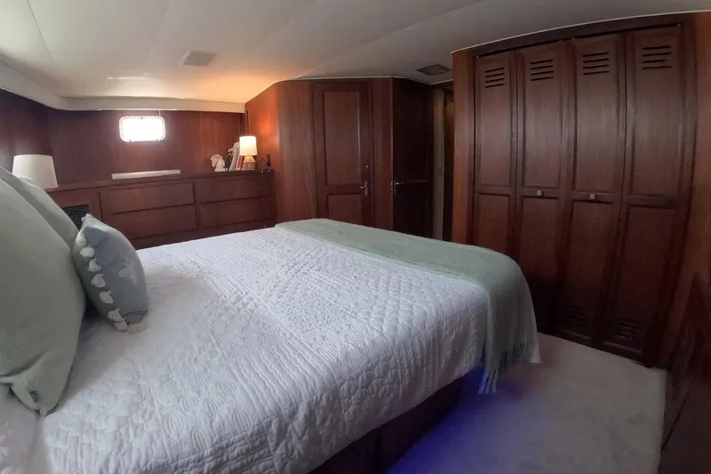 Slide: The Image of Luxurious bedroom interior of 1987 Hatteras 54 Motor Yacht with wood paneling and cozy bedding. - 27