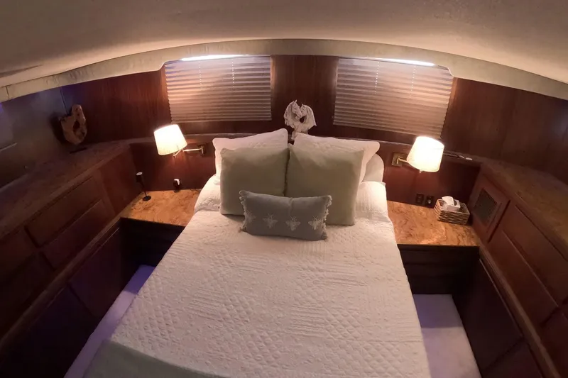 Slide: The Image of Cozy bedroom interior of 1987 Hatteras 54 Motor Yacht with elegant wood paneling. - 28