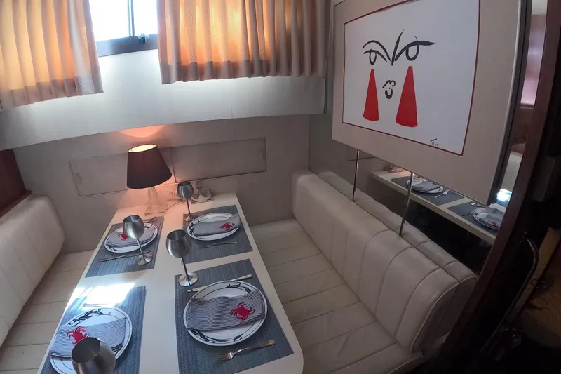 Slide: The Image of Dining area in 1987 Hatteras 54 Motor Yacht with modern art and elegant table setting. - 36