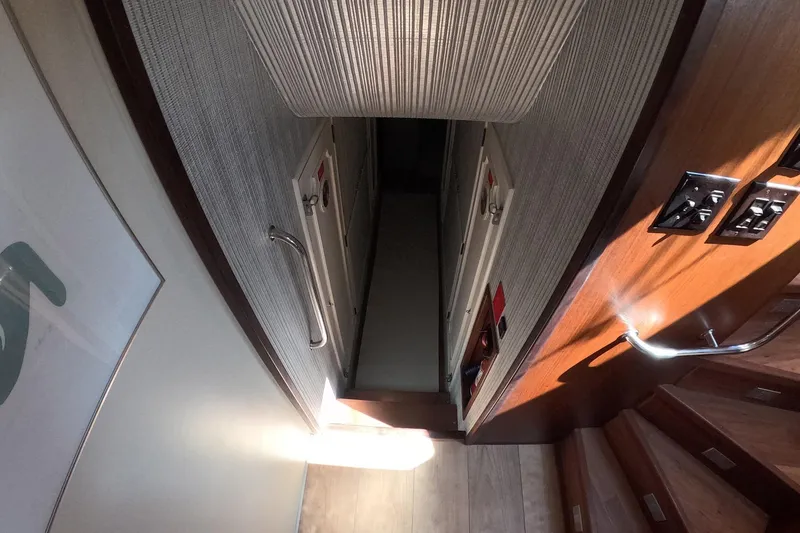 Slide: The Image of Interior hallway of a 1987 Hatteras 54 Motor Yacht with wooden stairs and modern design. - 37