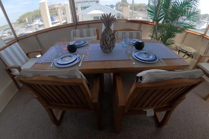 Slide: The Image of Elegant dining setup on 1987 Hatteras 54 Motor Yacht with nautical decor and wooden furniture. - 40