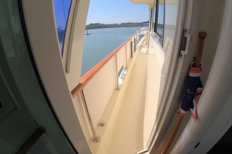 Slide: The Image of 1987 Hatteras 54 Motor Yacht deck view with railing and water backdrop. - 43