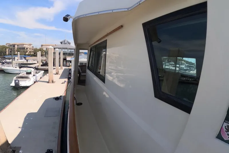 Slide: The Image of 1987 Hatteras 54 Motor Yacht docked at marina, showcasing side view and windows. - 48
