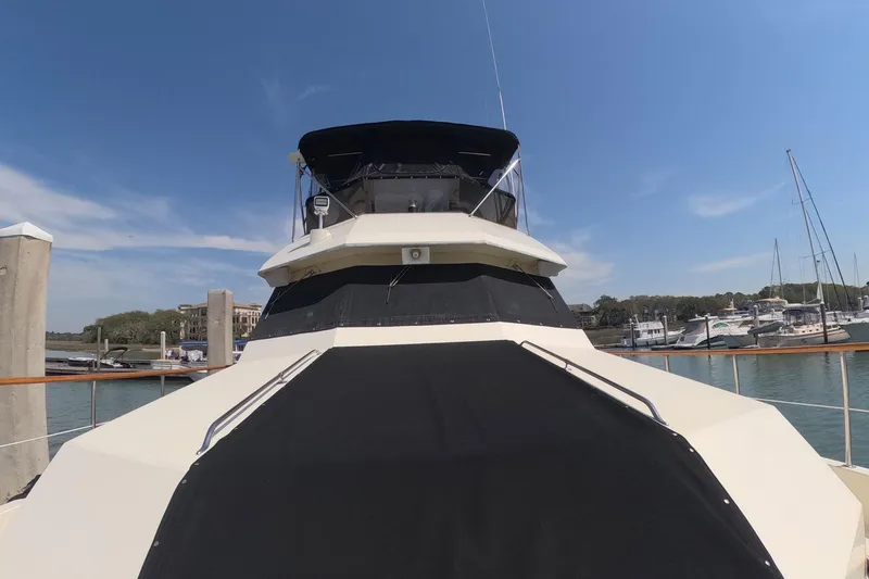 Slide: The Image of 1987 Hatteras 54 Motor Yacht docked at marina under clear blue sky. - 52