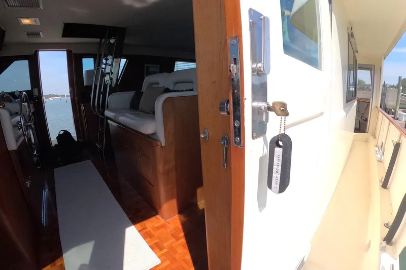 Slide: The Image of Interior view of 1987 Hatteras 54 Motor Yacht with open door and seating area. - 55