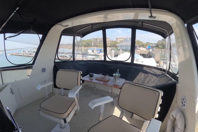 Slide: The Image of Interior of 1987 Hatteras 54 Motor Yacht with seating and table, overlooking marina. - 58
