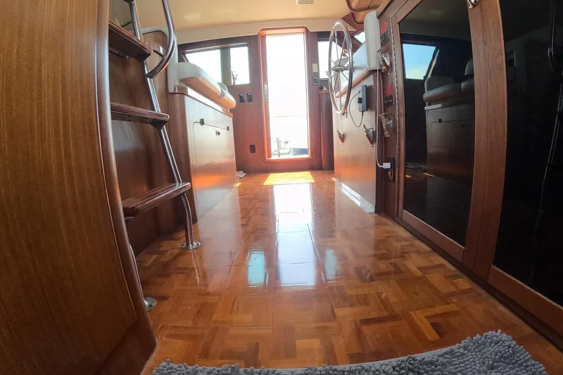 Slide: The Image of Interior of 1987 Hatteras 54 Motor Yacht with polished wood flooring and nautical decor. - 6