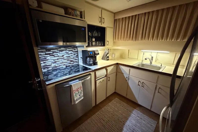 Slide: The Image of Compact kitchen in a 1987 Hatteras 54 Motor Yacht with modern appliances and backsplash. - 69